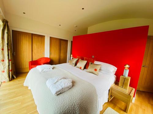 a bedroom with two beds with a red wall at Ardtorna in Benderloch