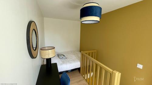 - une petite chambre avec un lit et une lampe dans l'établissement A la Clef - Duplex cosy proche gare et centre - Idéal PRO & Couple - WIFI, au Mans
