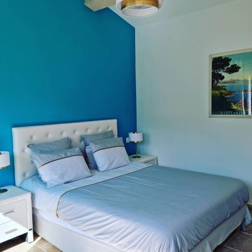 - une chambre bleue avec un lit aux murs bleus dans l'établissement L'EDEN PROVENCAL, à Fayence