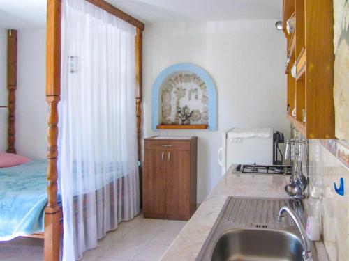 a kitchen with a sink and a bed at House Zelanto Mali in Tkon