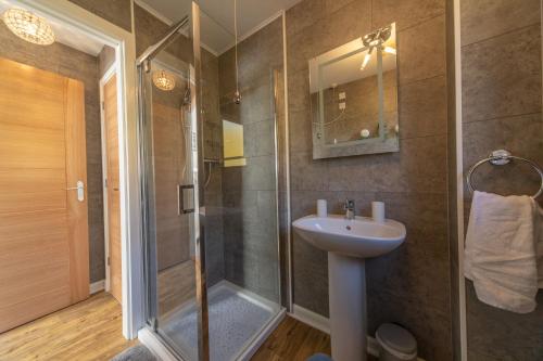a bathroom with a shower and a sink at Scalpay@Knock View Apartments, Sleat, Isle of Skye in Teangue