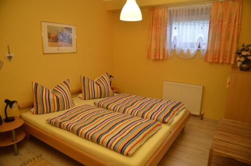 a bedroom with two beds with striped pillows at Ferienwohnung Möderndorfer, Fulpmes in Fulpmes
