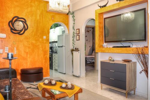 un salon avec une télévision sur un mur dans l'établissement Stone house under Acropolis, à Athènes