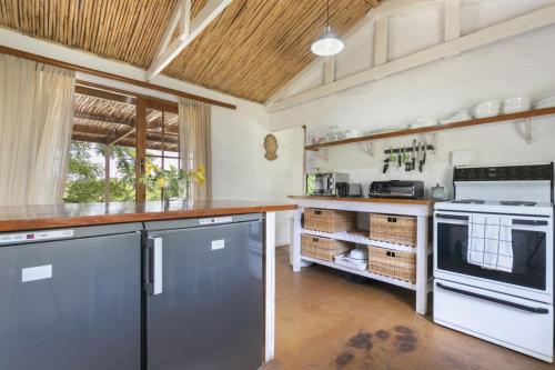 a kitchen with white appliances and a wooden ceiling at Waterfall Farm Self-Catering Cottages Citrusdal in Citrusdal