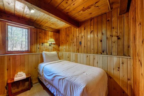 um quarto com uma cama num chalé de madeira em Saco Sunshine Delight em Lower Bartlett