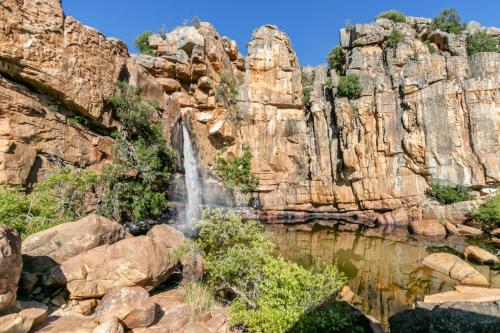 a waterfall in a canyon with rocks at Waterfall Farm Self-Catering Cottages Citrusdal in Citrusdal