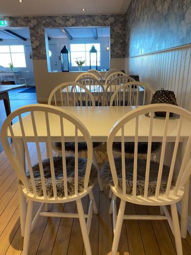 a dining room table with four chairs around it at Kaptenshuset Hotell in Kivik