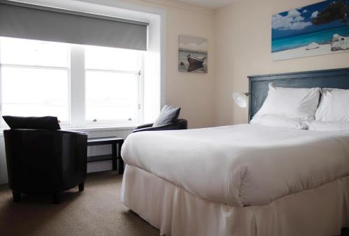 a bedroom with a bed and a desk and a window at The Boathouse in Anstruther