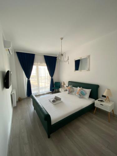 a bedroom with a large bed with blue curtains at Seafront Mamaia - Casa Del Mar Residence in Mamaia