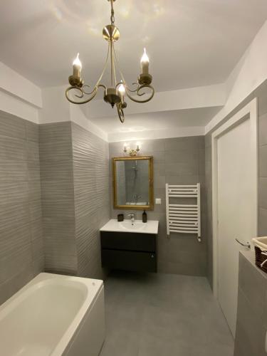a bathroom with a tub and a sink and a mirror at Seafront Mamaia - Casa Del Mar Residence in Mamaia
