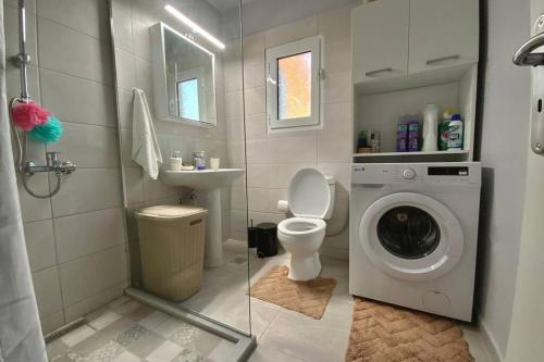 uma casa de banho com uma máquina de lavar roupa e um lavatório em Ι Love Home Gold em Kalamata