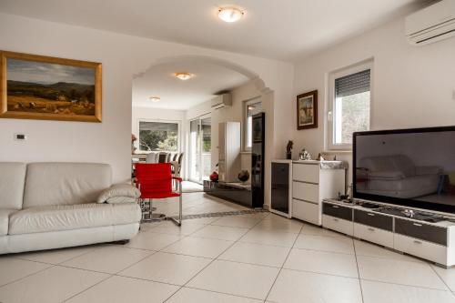 a living room with a couch and a flat screen tv at Heart of Strunjan Apartments AL in Strunjan
