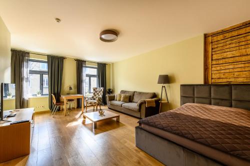 a bedroom with a bed and a living room at Liepaja Apartments Downtown in Liepāja