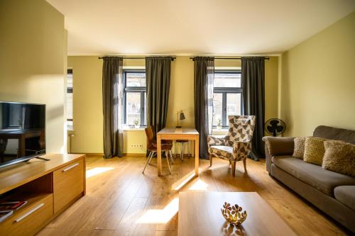 un soggiorno con divano e tavolo di Liepaja Apartments Downtown a Liepāja
