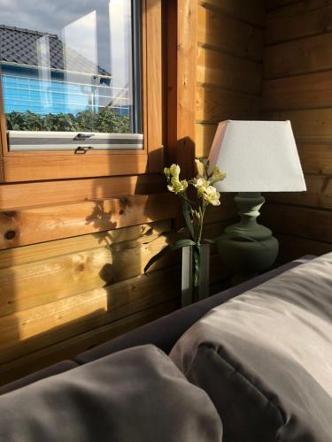um quarto com uma cama, um candeeiro e uma janela em 6 persoons vakantiehuis met sauna, dichtbij zee em Sint-Annaland