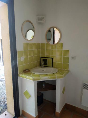 une salle de bain avec un lavabo et deux miroirs dans l'établissement Villa Bleucassis, à Taradeau