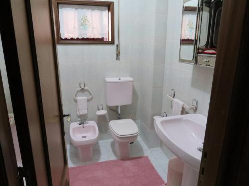 een witte badkamer met een toilet en een wastafel bij apartamento Vila do Conde in Vila do Conde