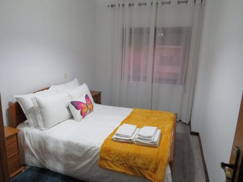 ein Schlafzimmer mit einem Bett mit zwei Handtüchern darauf in der Unterkunft apartamento Vila do Conde in Vila do Conde
