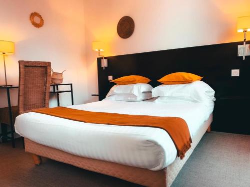 a bedroom with a large bed with orange and white pillows at Hotel Alexandra - Boutique Hotel in Juan-les-Pins