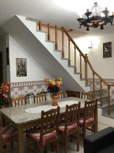 a dining room with a table and a staircase at Casa De Ferias Santos in Aguiar da Beira