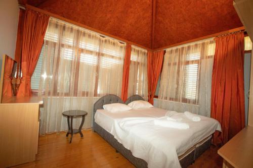 a bedroom with a bed in a room with windows at Magic Garden Apart in Kemer