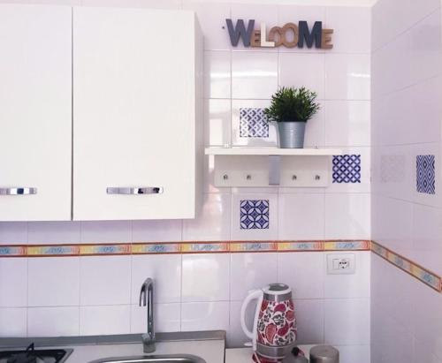 a kitchen with white cabinets and a sink at Casa vacanze Caterina in Naples