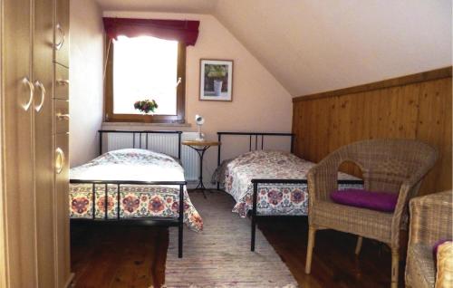 a bedroom with two beds and a window and a chair at Beautiful Home In Zechin- Friedrichsaue With Kitchen in Friedrichsaue