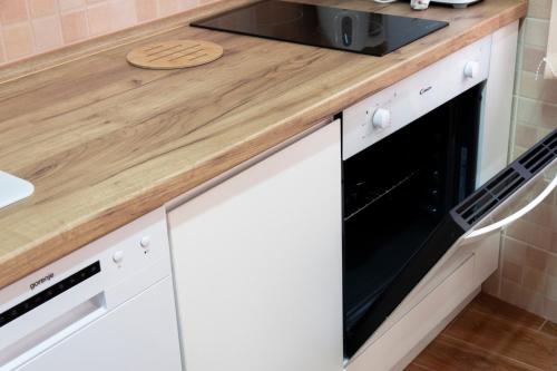 a kitchen with white cabinets and a black microwave at Lux Family Apartment Vidanovic in Pirot