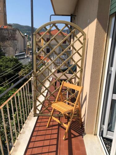 a wooden chair sitting on the side of a balcony at Appartamento in pieno centro a 100m dal mare in Spotorno