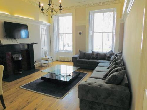 a living room with a couch and a coffee table at WEST END - Stunning, spacious, 3 bedroom, main door flat with private parking in Glasgow