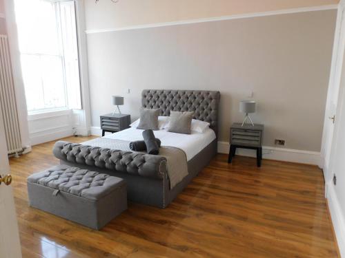 a bedroom with a large bed and a couch at WEST END - Stunning, spacious, 3 bedroom, main door flat with private parking in Glasgow
