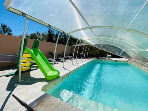 une piscine avec un toboggan et une piscine dans l'établissement Le gîte du golf, à Montauban