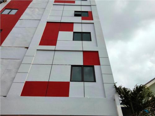 un edificio con plazas rojas y blancas. en Pondok Indah24 Hotel en Yakarta
