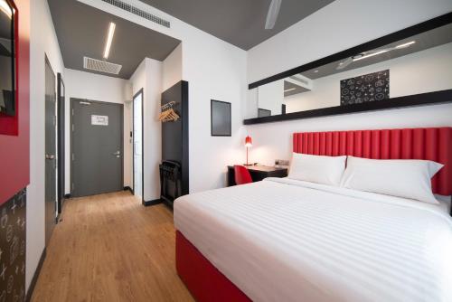 a bedroom with a large bed and a red headboard at Tune Hotel KLIA-KLIA2, Airport Transit Hotel in Sepang