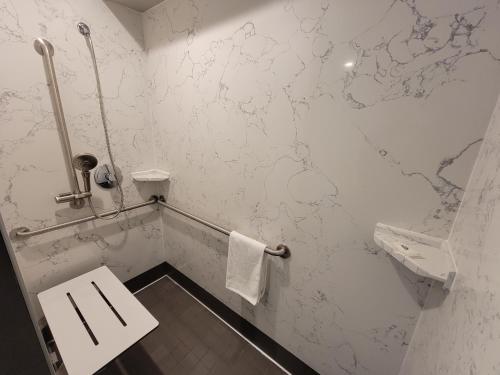 a white bathroom with a toilet and a sink at Signature Inn Santa Clara in Santa Clara