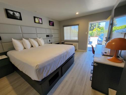 a bedroom with a bed and a desk with a lamp at Signature Inn Santa Clara in Santa Clara