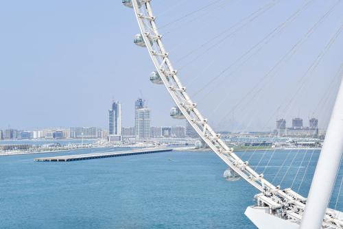 a bridge over the water with a city in the background at Spectacular 3 BR condo with maids room facing the Dubai Eye in Dubai