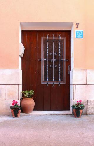 una puerta de madera con dos macetas delante de ella en Vivienda Turística el Ciclamen, en Mora de Rubielos