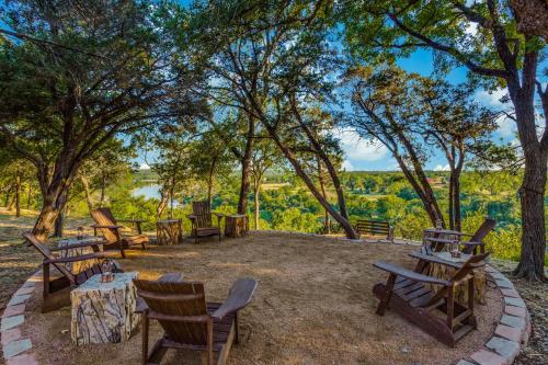 a group of tables and chairs in a park with trees at Rest Yourself River Ranch in Mineral Wells