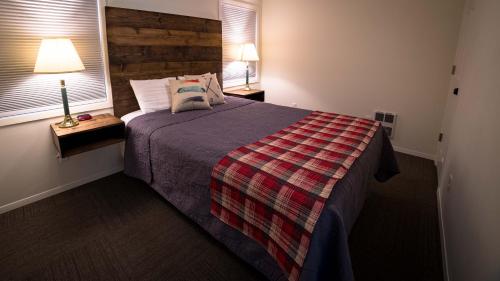 a bedroom with a bed with a plaid blanket at Eagle Cap Chalets in Joseph