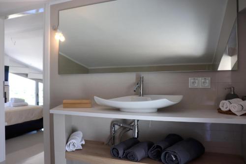 a bathroom with a sink and a mirror at ASSINI View in Asíni