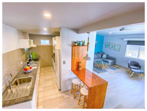 a kitchen and living room with a sink and a table at Ocean Escape Resort & Spa in Rarotonga