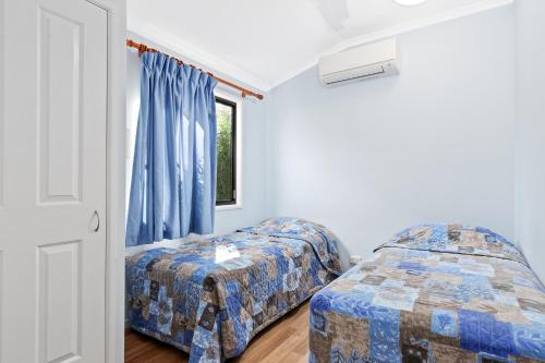 a bedroom with two beds and a window at Southside Holiday Village in Rockhampton