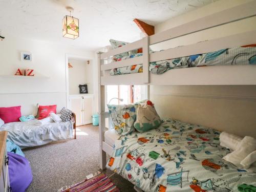 a bedroom with bunk beds and a bed at Spring Cottage in Ilfracombe