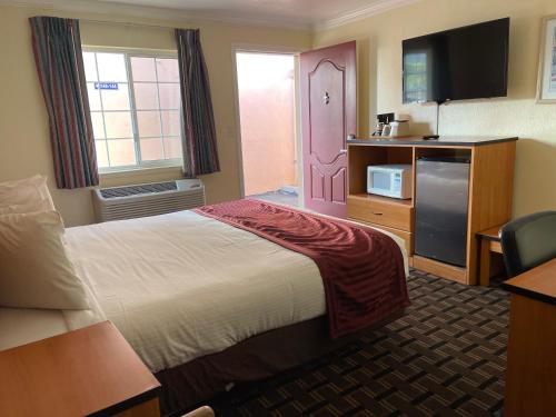 a hotel room with a bed and a tv at Riverside Inn & Suites Santa Cruz in Santa Cruz