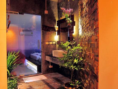 baño con lavabo y pared de ladrillo en Forest Bungalows & Mama's Restaurant, en Chalong 