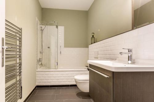 ein Bad mit einem WC, einem Waschbecken und einer Dusche in der Unterkunft Art your Life Residenz Seeburg Whg 4 in Westerland