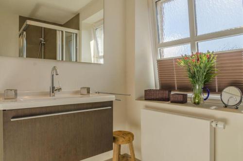 ein Bad mit einem Waschbecken und einem Spiegel in der Unterkunft Haus Hauke Whg 1 in Westerland