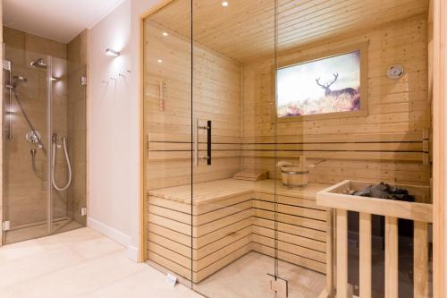 een badkamer met een sauna en een glazen douchecabine bij Hoeoeg Hues Whg 3 in Wenningstedt
