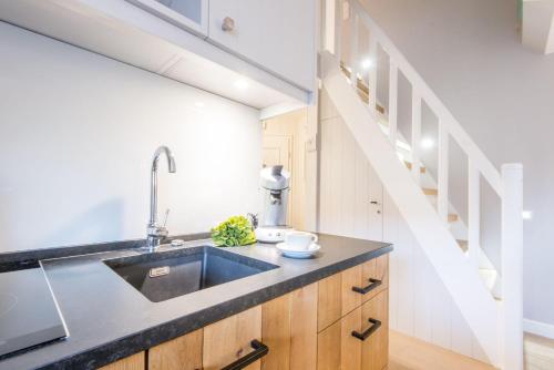 eine Küche mit Spüle und Treppe in der Unterkunft Witthues Miin Luett in Wenningstedt-Braderup